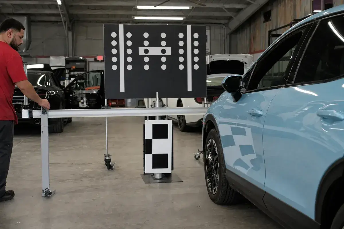ADAS calibration target boards set up in front of a vehicle at Podium Body Works in Round Rock, Texas