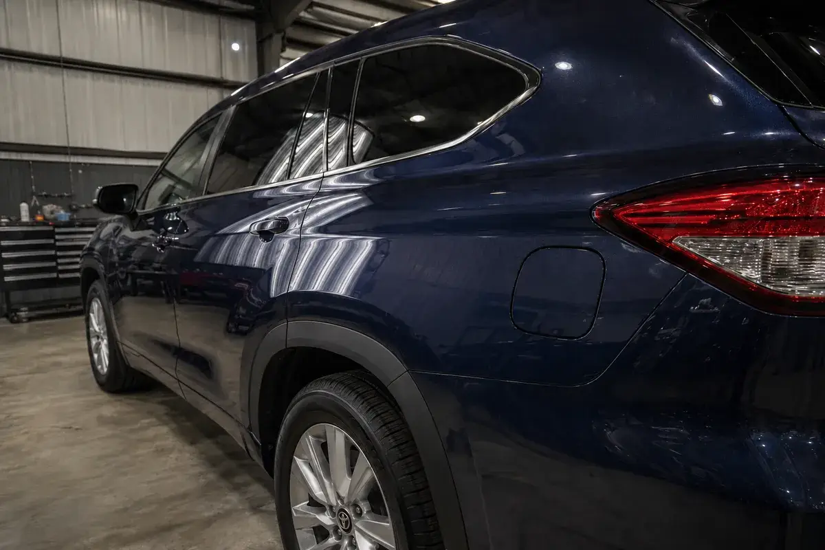 A blue Toyota Highlander side panel with a smooth finish after paintless dent repair at Podium Body Works in Round Rock, Texas