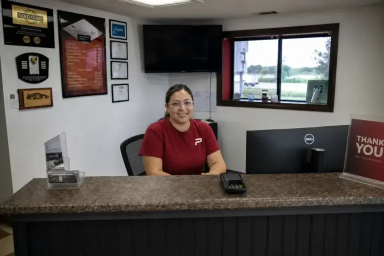 A staff member at the front desk reception area at Podium Body Works in Round Rock, Texas