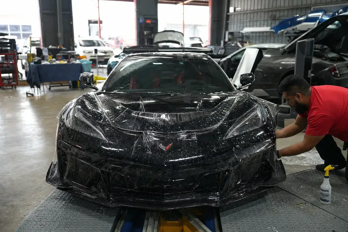 A car front end fully wrapped in clear protection film at Podium Body Works in Round Rock, Texas