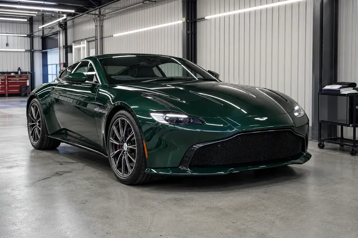 A green Aston Martin Vantage in the shop for exotic collision repair at Podium Body Works in Liberty Hill, Texas