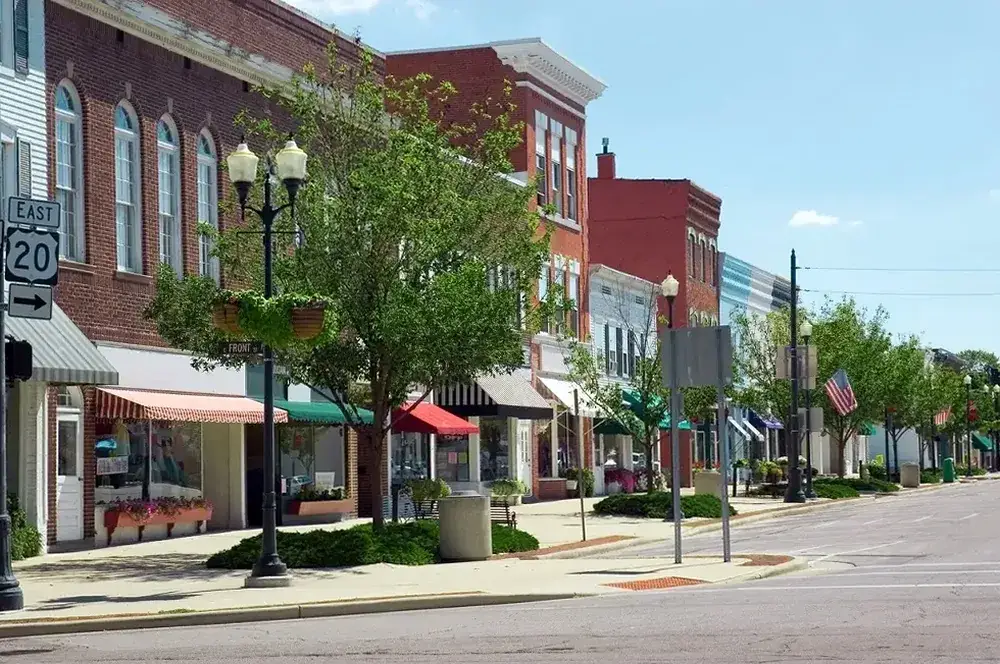 A downtown main street with brick storefronts in Leander, Texas, part of the area Podium Body Works serves