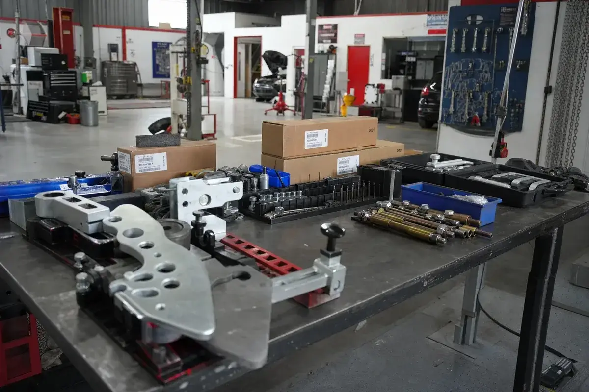 Factory tooling and genuine parts in a Porsche certified bay at Podium Body Works in Liberty Hill, Texas