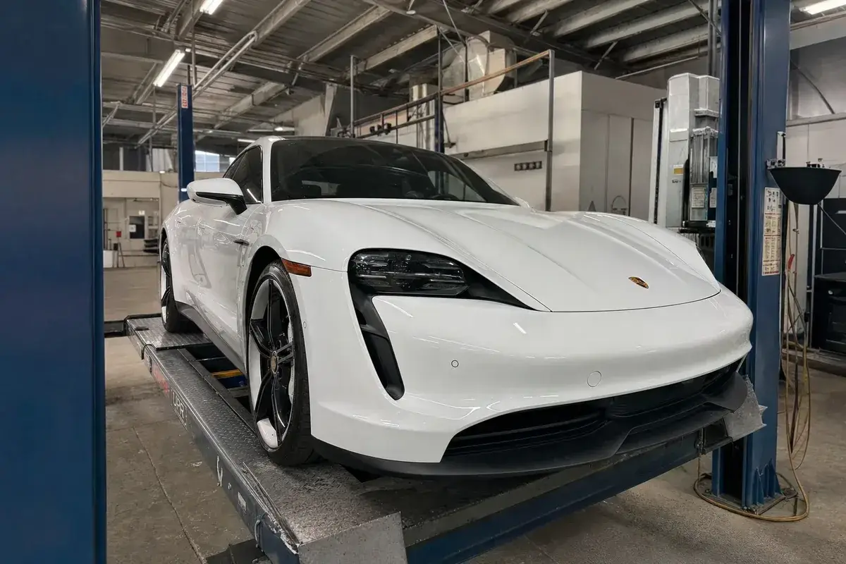 A Porsche on a lift in the certified repair bay at Podium Body Works in Liberty Hill, Texas