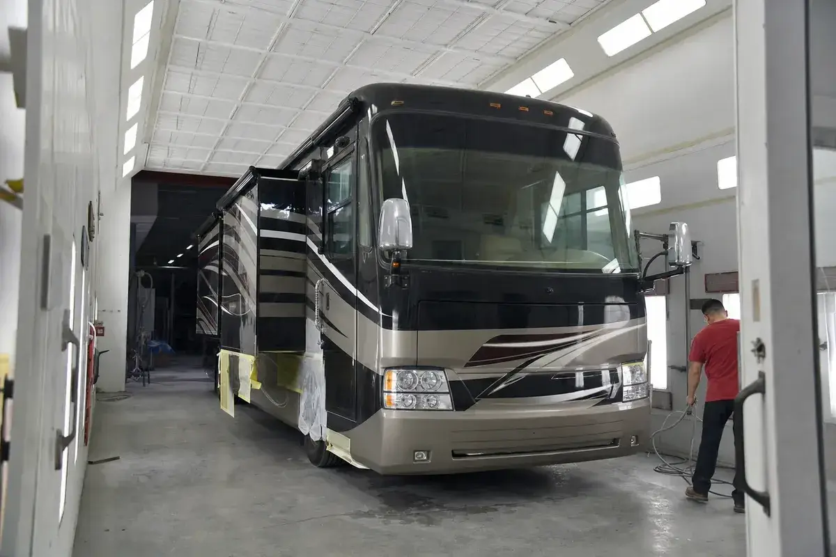 A large motorhome inside the oversized paint booth at Podium Body Works in Liberty Hill, Texas